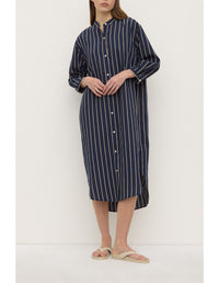 Person wearing a navy and white striped dress against a white background