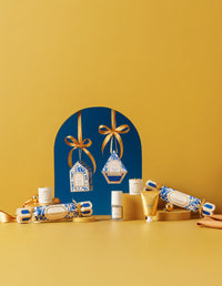 CHRSITMAS GIFTS with decorative boxes and bottles on a yellow background