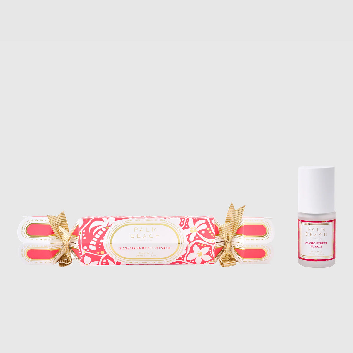 Fragrance roll-on and bottle with decorative packaging on a light gray background