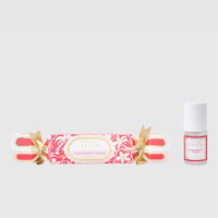 Fragrance roll-on and bottle with decorative packaging on a light gray background