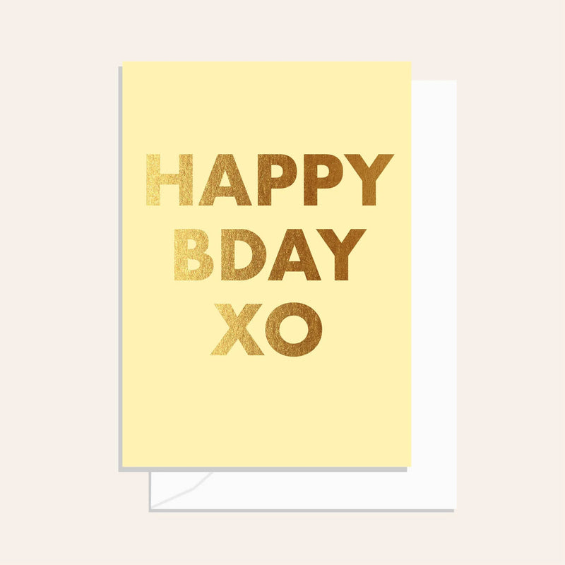 Yellow card with gold text 'Happy Birthday XO' on a light pink background