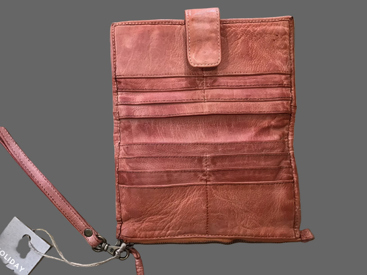 Tan leather wallet with strap on a wooden surface