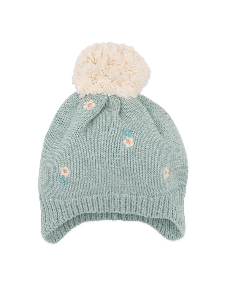 Green knitted baby hat with white pom-pom and floral embroidery on a white background