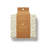 Packaged organic cotton fitted bassinet sheet with floral design on a beige background