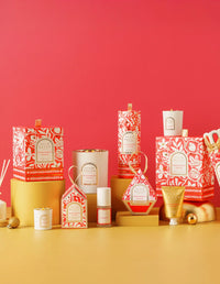 Assorted candles and decorative items on a yellow surface with a red background