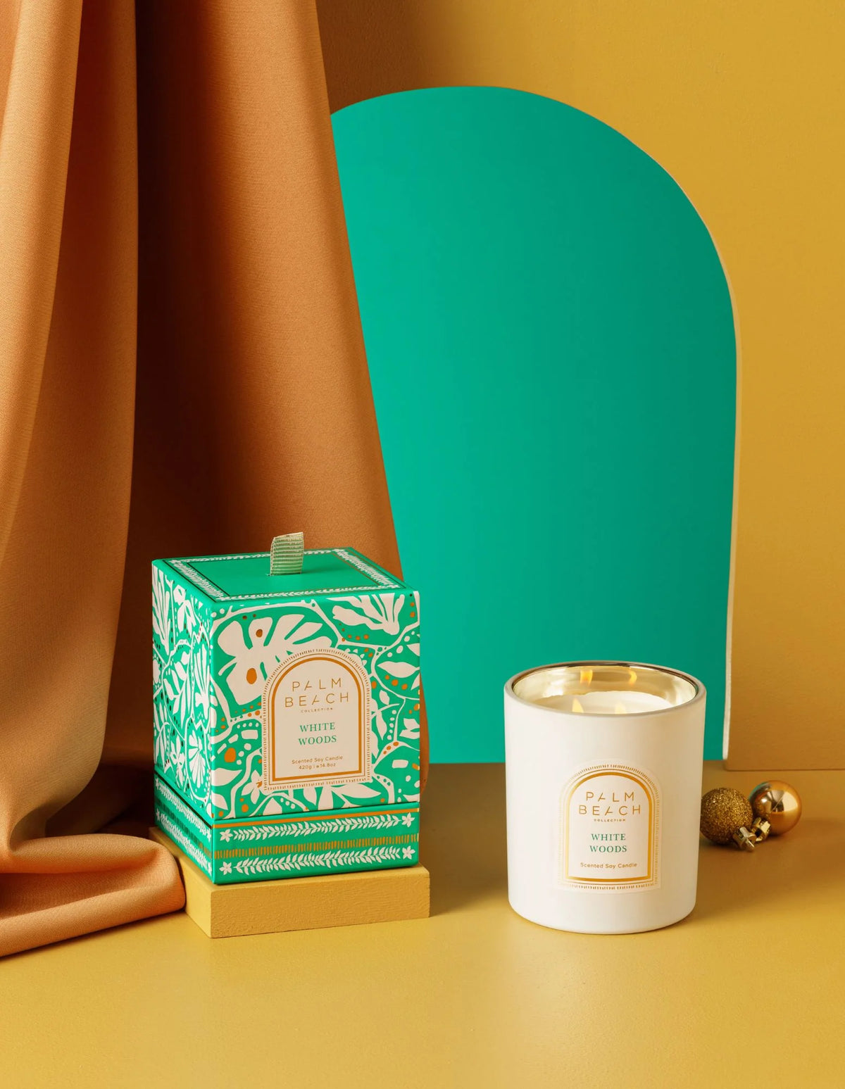 Candle and packaging with decorative elements on a yellow background